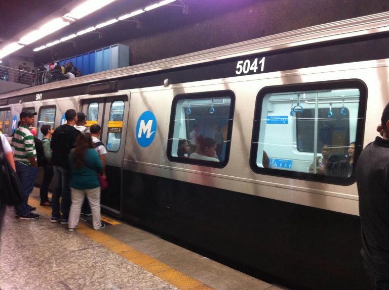 Passageiros se aglomeram na porta do metrô na esperança de conseguir um lugar sentado