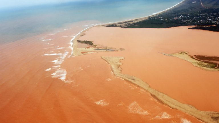O Rio Doce com as águas vermelhas do minério de ferro já no território do Espírito Santo, em novembro passado (AFP/Estado do Espírito Santo/Fred Loureiro)