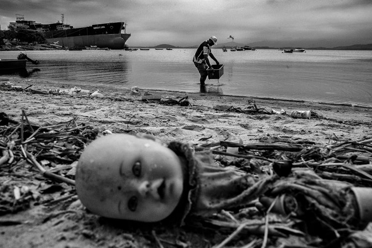 Homem pesca caranguejos na Baía de Guanabara em meio à sujeira (Foto Dario De Dominicis)
