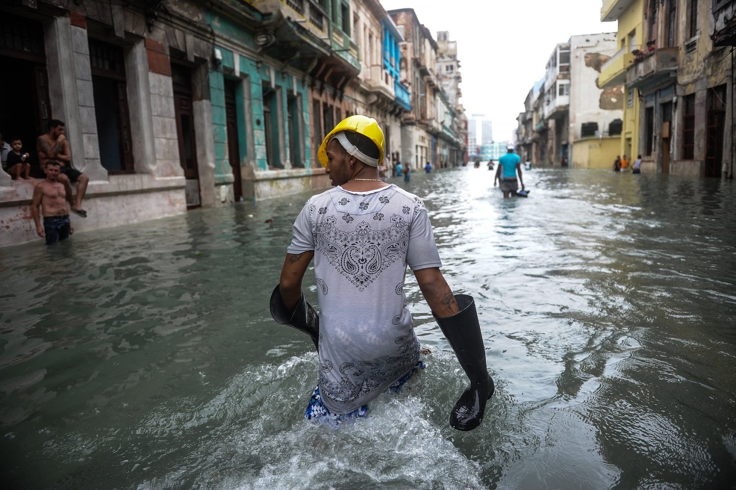 Foto Yamil Lage/AFP Cubano atravessa uma das ruas inundadas de Havana. Foto Yamil Lage/AFP
