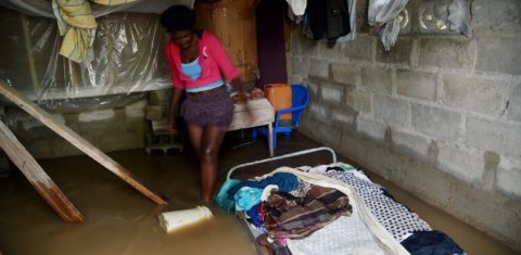 Marie Charlotte caminha dentro da sua casa, no Haiti, inundada pelo furacão Irma. Foto Hector Retamal/AFP