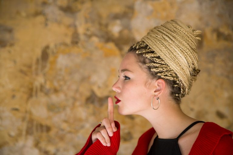 Profile of young woman with dreadlocks, finger to mouth. Foto de Russ Rohde/ Cultura Creative/ AFP