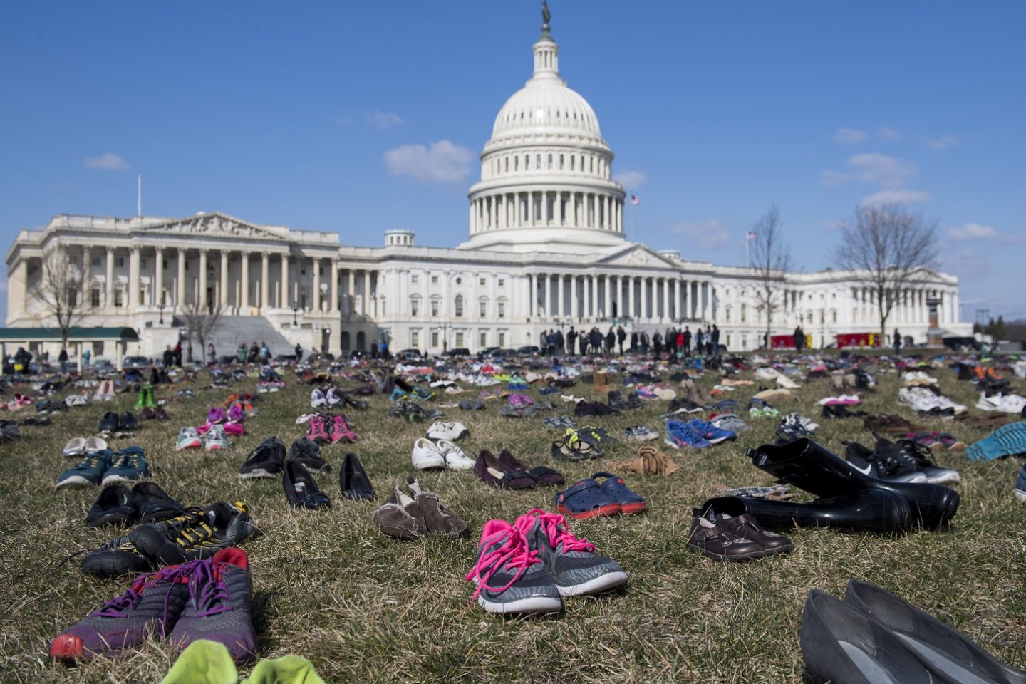 Em um protesto em frente ao Capitólio, em Washington, sete mil pares de calçados lembram as crianças mortas por arma de fogo no país. Foto Saul Loeb/AFP
