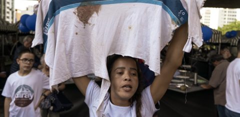 Bruna Silva segura a camisa da escola que seu filho Marcus Vinícius usava no dia em que foi morto. Foto: Daniel Arroyo