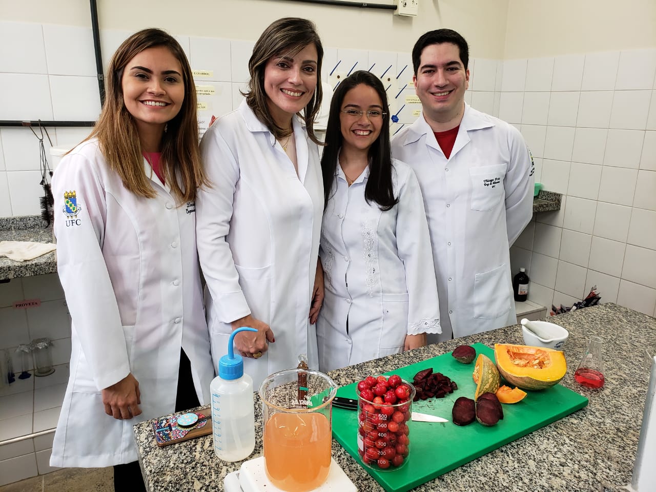 A professor Lucicléia Barros com seus alunos e inventores do Netchup, Lorena Freire, Bárbara Denise de Oliveira e Thiago Tajra no laboratório da universidade: pesquisas continuam mesmo após lançamento do molho (Foto: Divulgação/UFC)