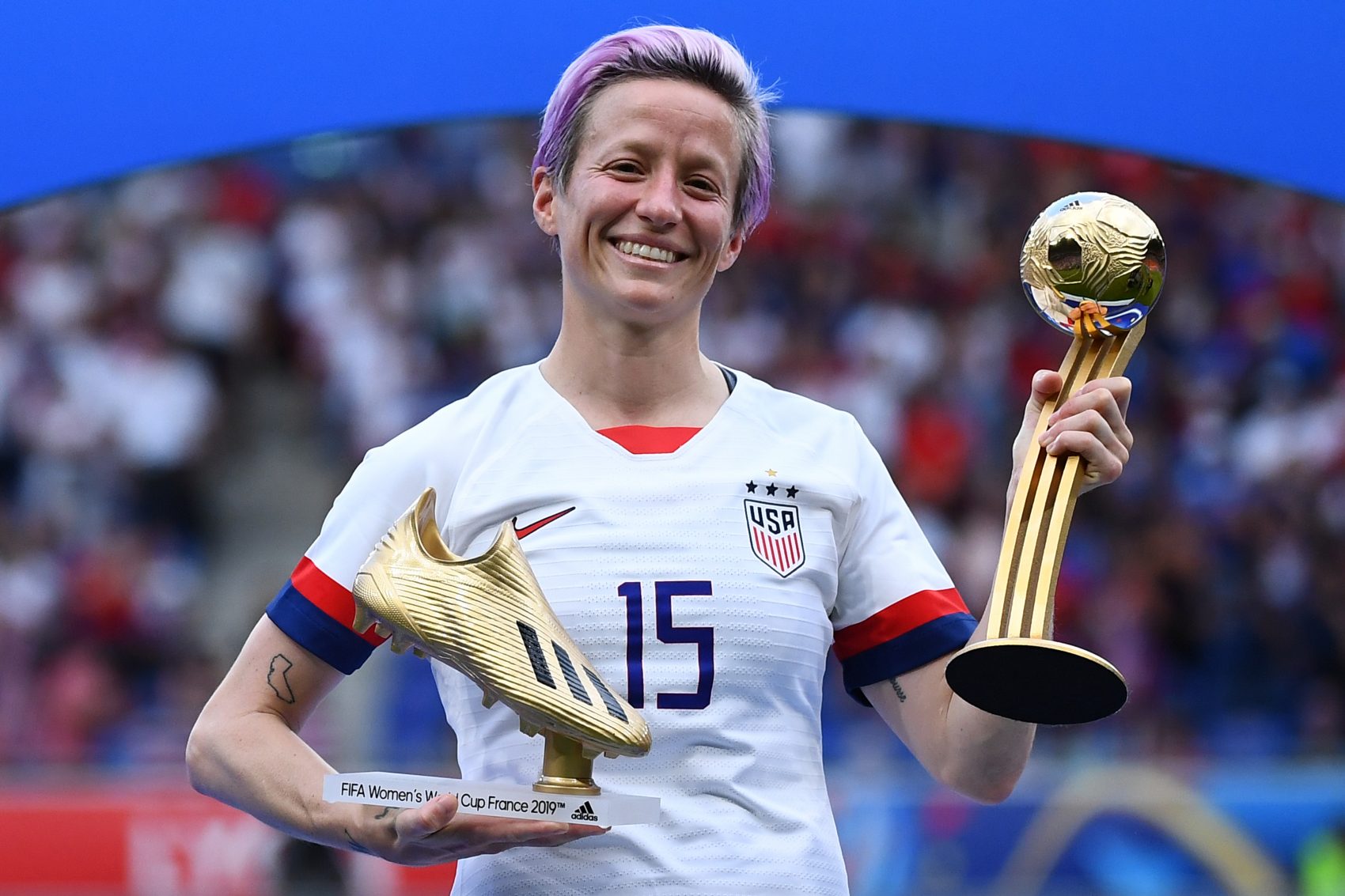 Megan Rapinoe com a Chuteira de Ouro de Artilheira e a Bola de Ouro de Melhor Jogadora: líder de campanha por igualdade salarial (Foto: Franck Fipe/AFP)