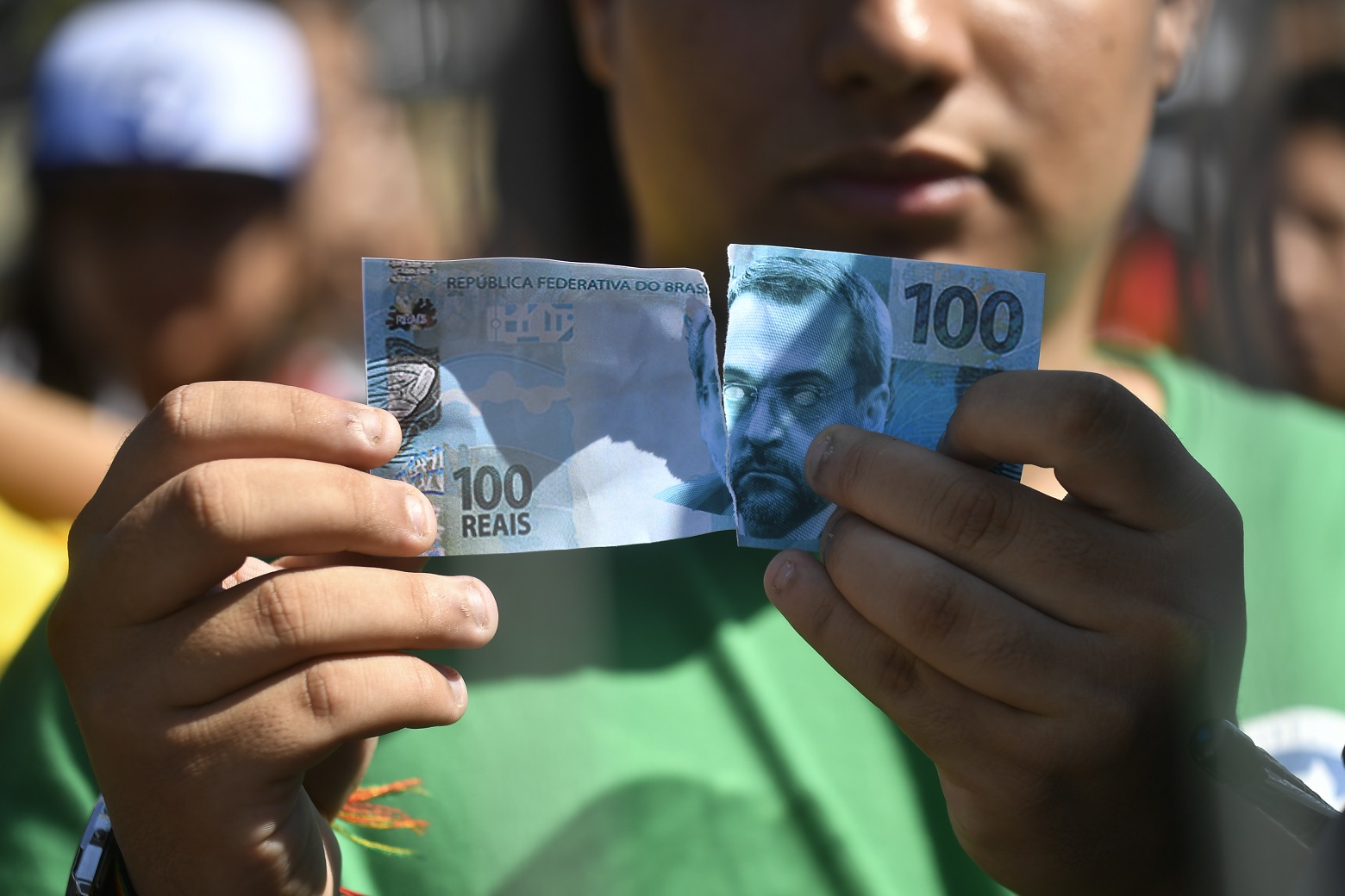 Manifestante rasga cédula falsa com a foto do ministro Abraham Weintraub. em protesto em frente ao MEC: críticas a criação de fundo de natureza privada para financiar educação pública (Foto: Mateus Bonomi/AGIF)