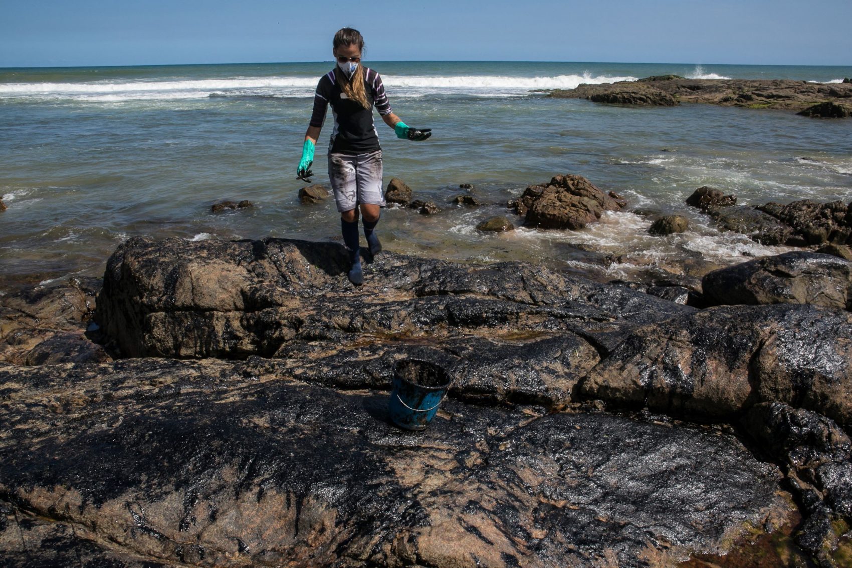 Ambientalista tira óleo das pedras da Pedra do Sal, em Salvador: Marinha teme que mais toneladas de óleo cheguem às praias brasileiras (Foto: Antonello Veneri/AFP)