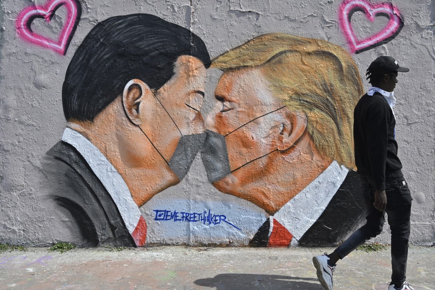 Em Berlim, uma pintura mural do grafiteiro Eme Freethinker apresenta imagens do presidente dos EUA, Donald Trump, e do premier chinês, Xi Jinping, usando máscaras contra a covid-19. Foto John MacDougall/AFP