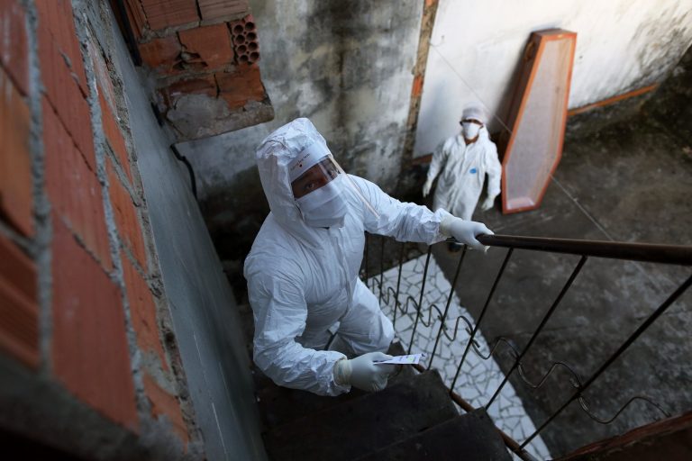 Funcionários da prefeitura de Manaus chegam para recolher o corpo de uma pessoa suspeita de ter morrido de covid-19. Foto Michael Dantas/AFP