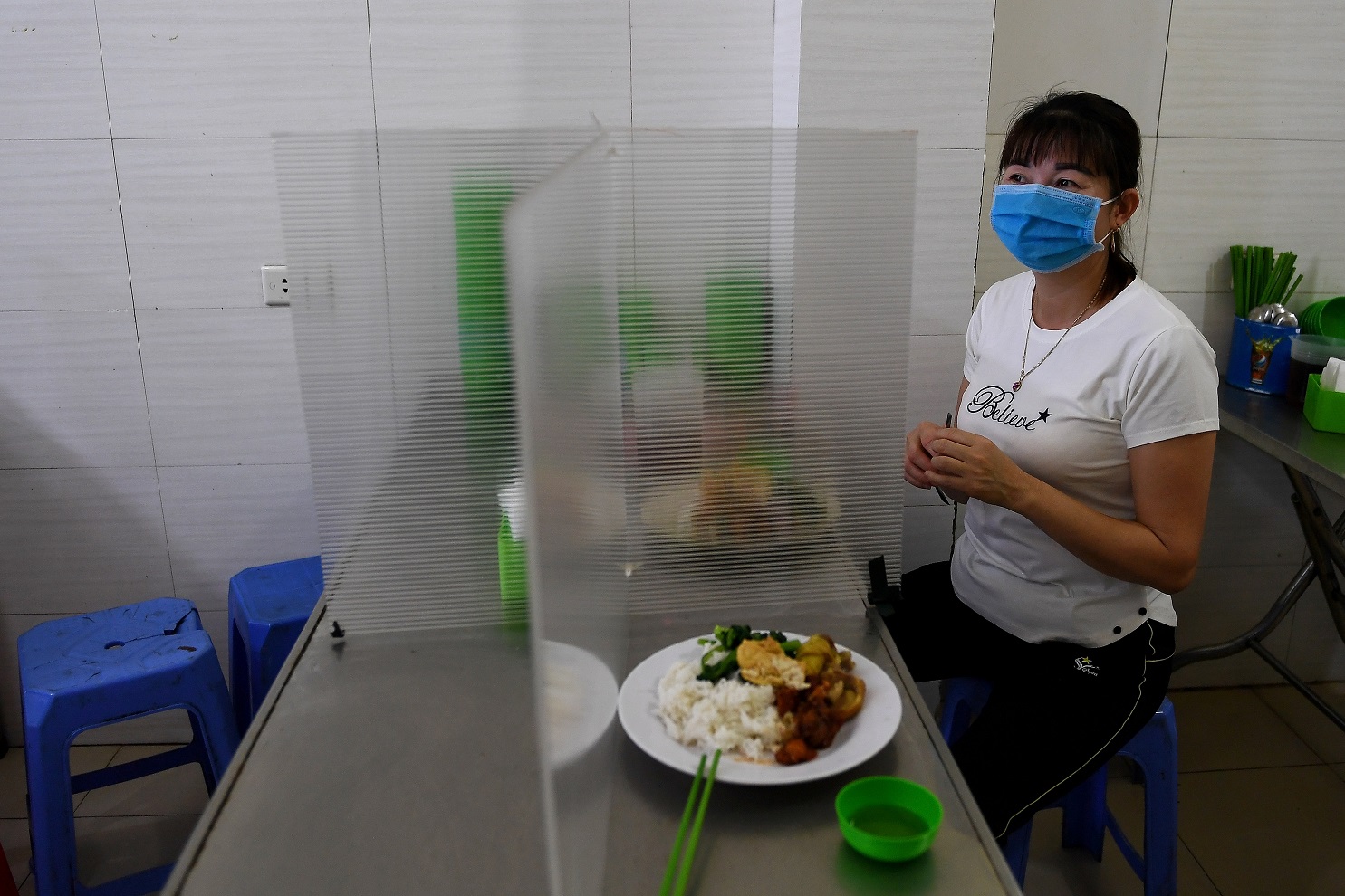 Foto Nhac Nguyen/AFP Em Hanoi, no Vietnã, uma divisória de plástico no restaurante serve como mais uma medida de prevenção contra o coronavírus. Foto Nhac Nguyen/AFP