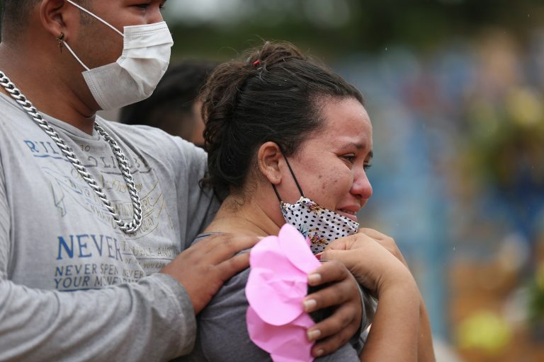 Valcione Soares e Vitor Soares choram a morte de sua avó Enedina Soares, de 71 anos, vítima de covid-19, durante seu enterro no cemitério de Nossa Senhora da Piedade, em Manaus. Foto Michael Dantas/AFP