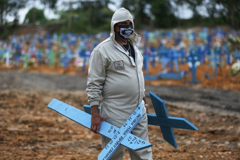 Em meio à pandemia de coronavírus, Ulisses Xavier, que trabalha há 16 anos no cemitério Nossa Senhora da Piedade, em Manaus, se prepara para colocar cruzes nas sepulturas. Foto Michael Dantas