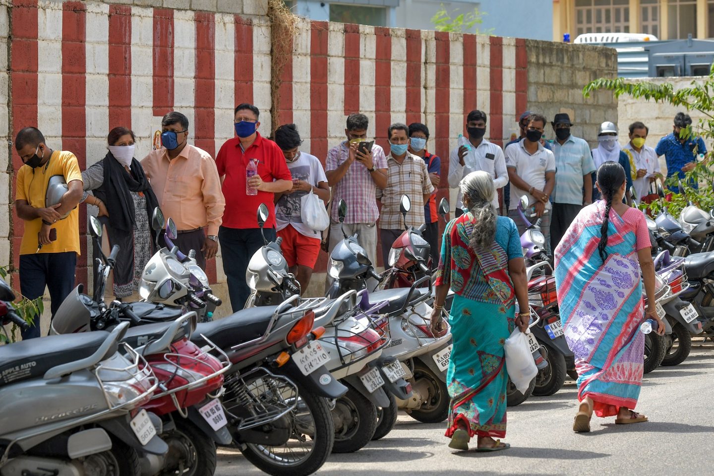 Indianos fazem fila na frente de um hospital particular em Bangalore para obter medicamentos alternativos que ajudariam na prevenção contra o coronavírus. Foto Manjunath Kiran/AFP