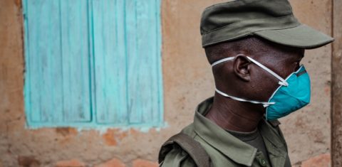 Representante da Unidade Local de Defesa (LDU), força paramilitar composta por civis, entrega farinha e feijão em alguns bairros de Uganda durante a quarentena. Foto Sumy Sadurni/AFP