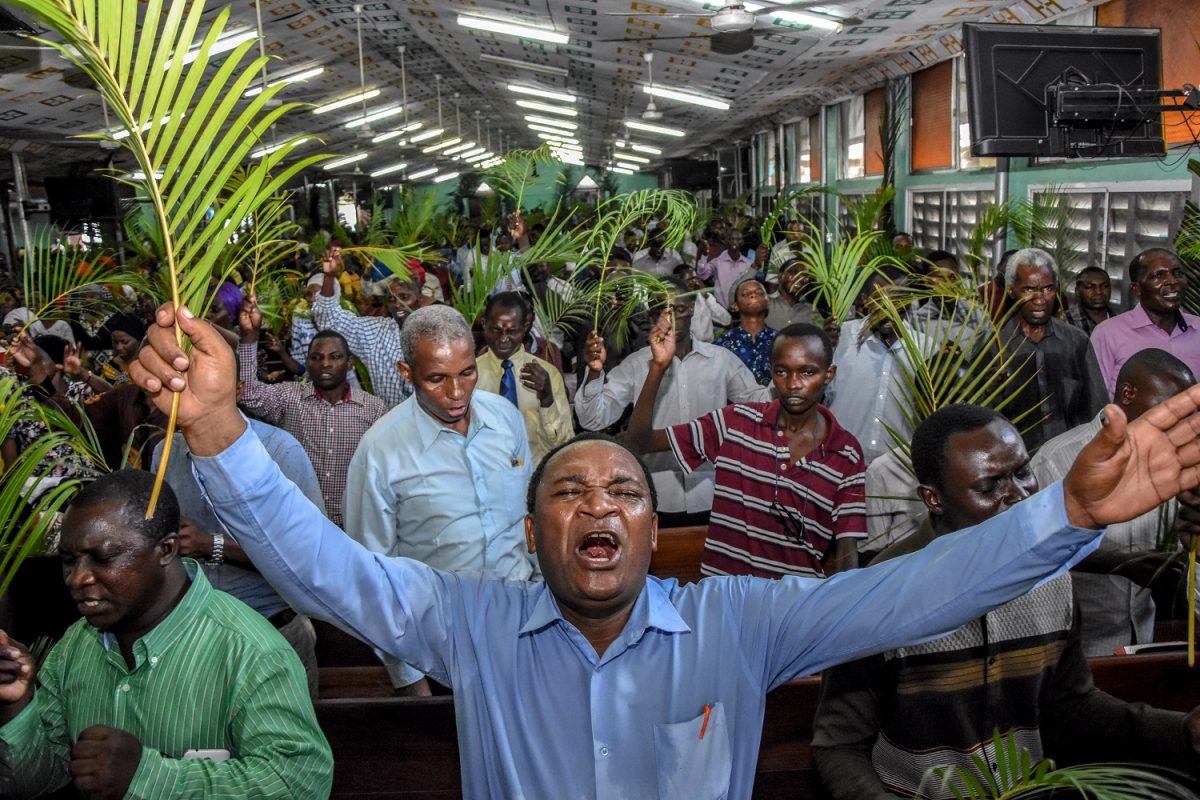 Fiéis oram sem usar máscaras e sem respeitar o distanciamento social durante uma missa do Domingo de Ramos na Igreja do Evangelho Completo, em Dar es Salaam, na Tanzânia. Foto Ericky Boniphace/AFP