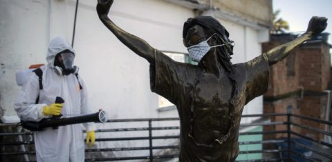 Voluntário desinfeta a estátua de Michael Jackson na favela Santa Marta, no Rio de Janeiro. Foto Mauro Pimentel