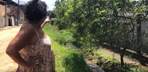 A dona de casa Maria de Fátima de Souza mostra o esgoto a céu aberto em Campos Elíseos: associação de moradores calcula que 80% das ruas do distrito não tem saneamento básico (Reprodução)