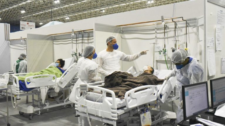 Profissionais de saúde cuidam de pacientes em hospital de campanha do Rio: Brasil tem a menor média de mortes desde maio (Foto: Fabio Teixeira/Agência Andalou/AFP)