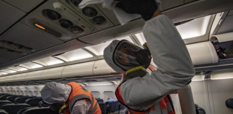 Trabalhadores com macacões de biossegurança desinfetam um avião, no hangar da LATAM, no aeroporto internacional El Dorado, em Bogotá. Foto Juan Barreto/AFP