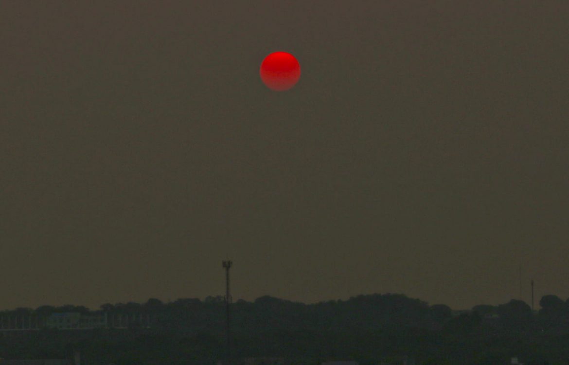 Pôr do sol em Manaus com uma densa cortina de fumaça: calor de 37 graus e falta de energia elétrica (Foto: Wilsa Freire/Amazônia Real)