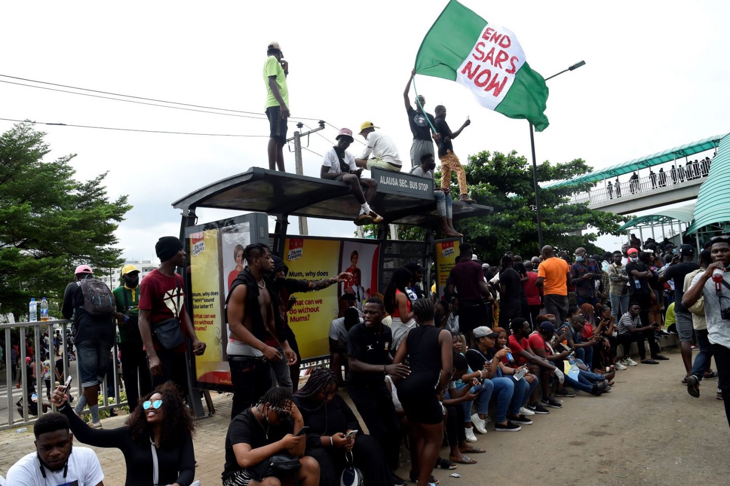 Manifestante com bandeira da Nigéria e a exigência de fim de esquadrão acusado de violência: hashtag #EmdSARS mobilizou nigerianos e espalhou protesto por outros países (Foto: Pius Utomi EKpei / AFP)