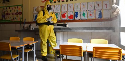 Funcionário do governo do Distrito Federal desinfeta uma escola pública como medida preventiva contra a disseminação da covid-19. Foto Evaristo Sá/AFP