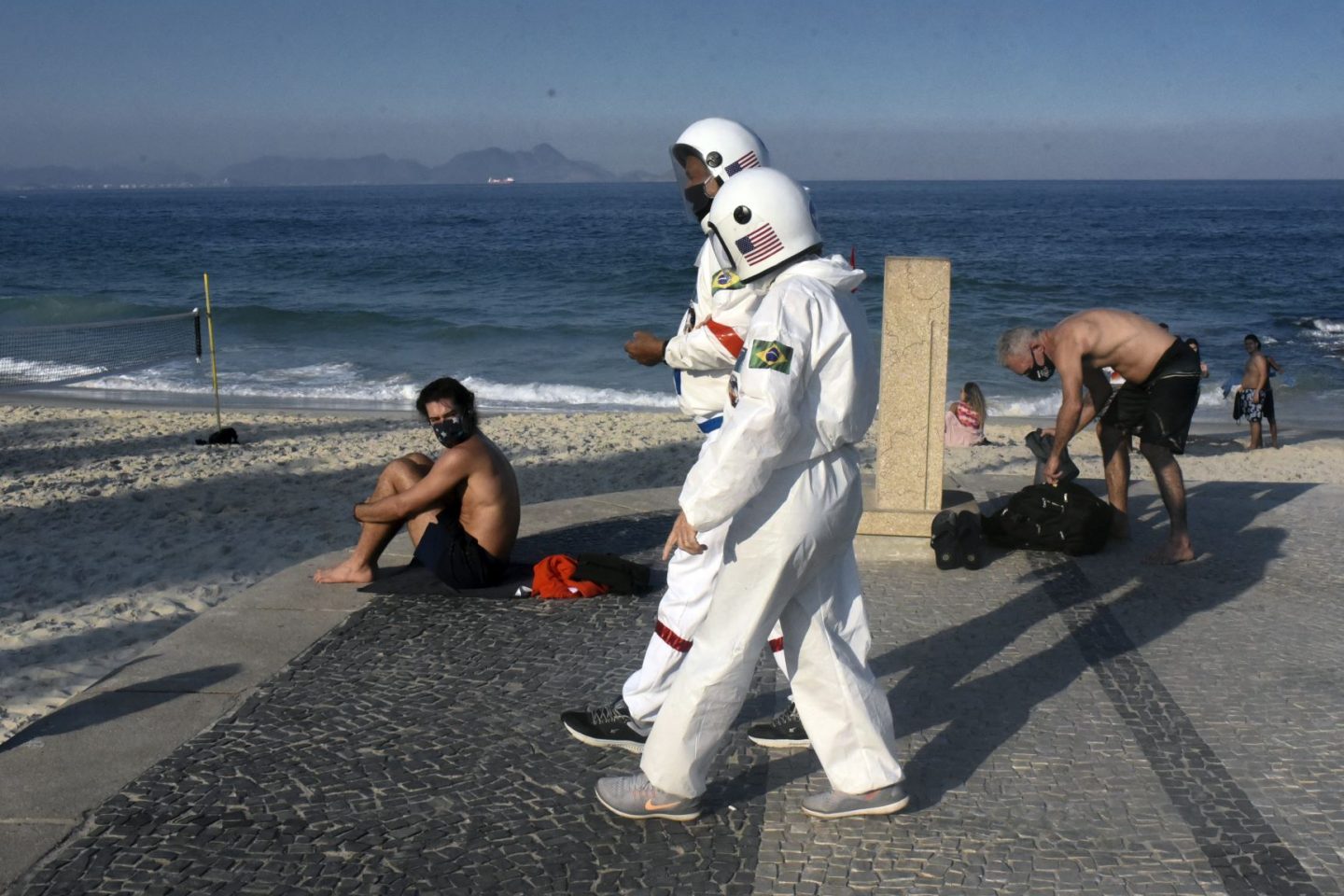 Casal de idosos caminha em Ipanema, no Rio, vestido de astronauta, na semana em que o Brasil bateu o recorde de mortes e casos (Foto: Fabio Teixeira/Andalou/AFP)