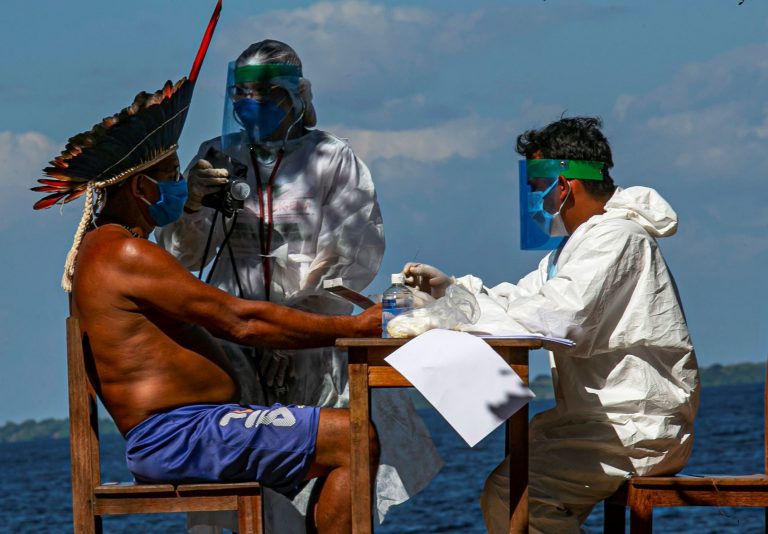 Enfermeiros indígenas da Sesai testam o cacique Domingos, da etnia Arapium, em aldeia às margens do Rio Tapajós, perto de Santarém, no Pará: Amazônia brasileira tem mais de 12 mil indígenas com covid-19 (Foto: Tarso Sarraf/AFP)