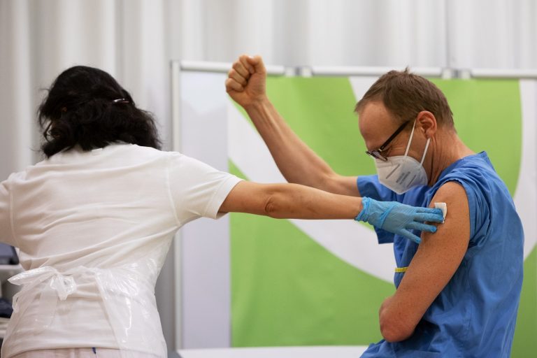 Em Viena, na Áustria, um profissional de saúde comemora ao receber a primeira dose da vacina da Pfizer-Biontech contra a covid-19. Foto Alex Halada/AFP