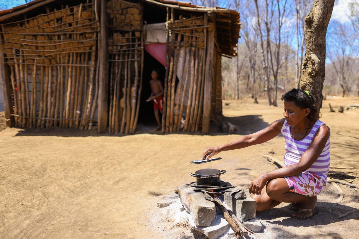 Laurinha Gomes cozinha um macarrão, sua - e do filho - única refeição do dia na aldeira indígena Xakriabá, em São João das Missões: rotina de fome e miséria, agravada pela ameaça do coronavírus (Foto: Flavio Tavares/Projeto Colabora)