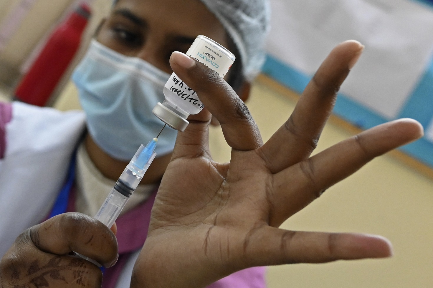 Profissional de saúde se prepara para administrar uma dose da vacina contra o coronavírus a um funcionário municipal em um centro de vacinação em Nova Delhi, na Índia. Foto Sajjad Hussain/AFP. Fevereiro/2021