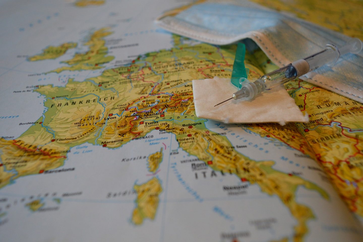 Turismo de vacina: máscara e seringa em cima de um mapa da Europa