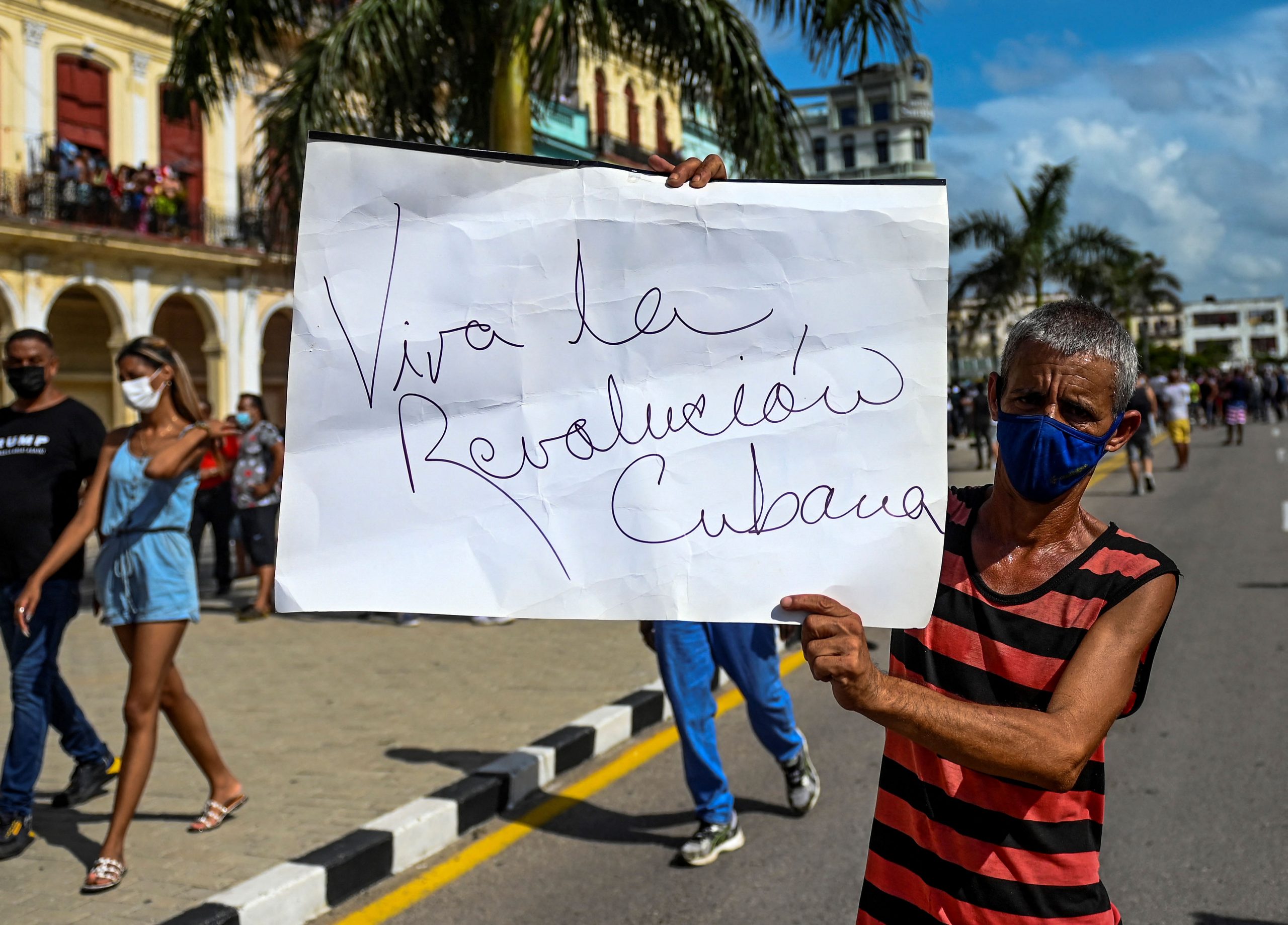 Defensor do governo de Miguel Diaz-Cnal ergue o cartaz com a frase histórica: "Viva a revolução cubana!" Foto Yamil Lage/AFP