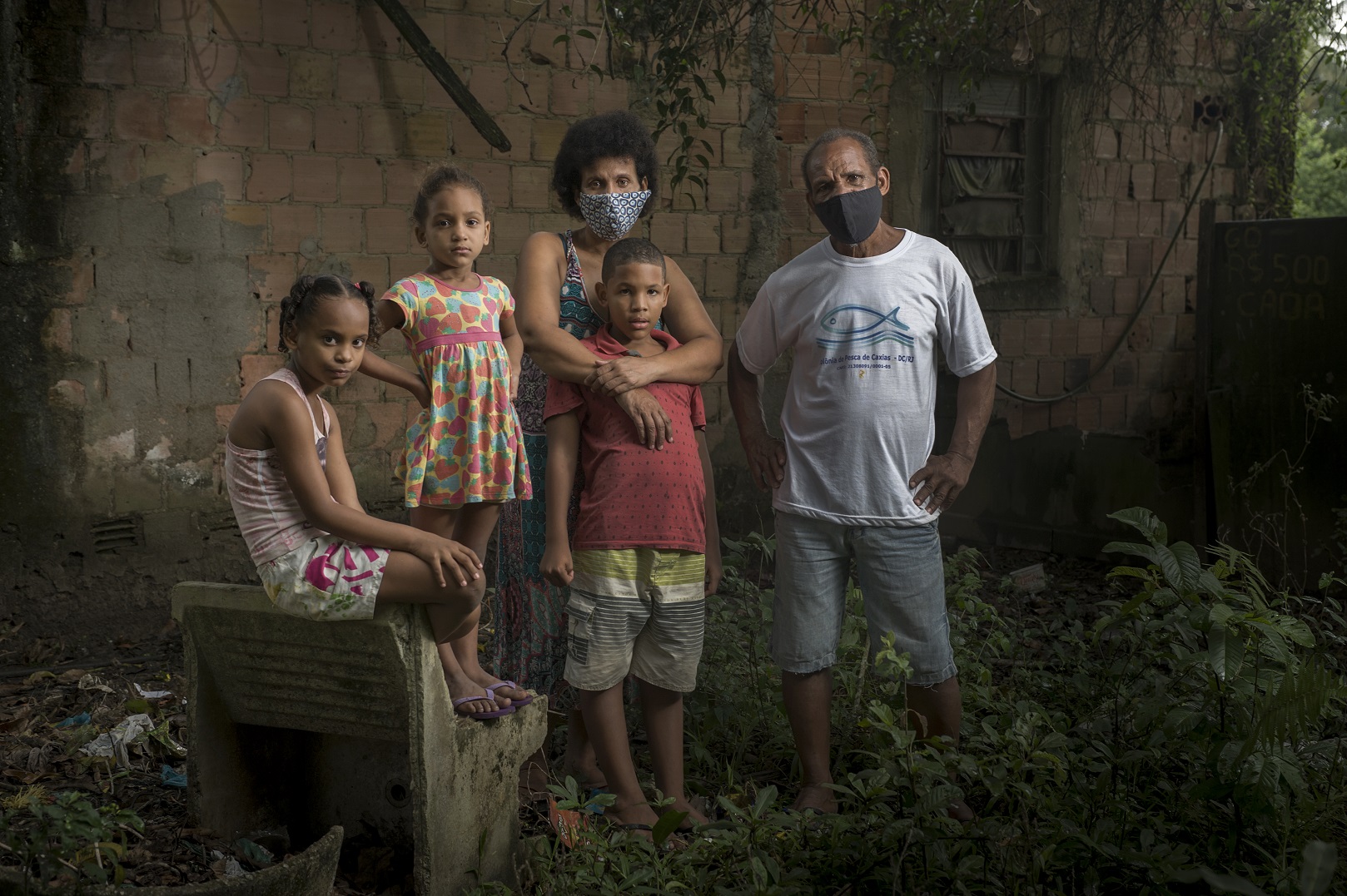 Os três filhos menores do pescador Gilciney Lopes Gomes, de camisa branca, morador de Caxias, Rio de janeiro, não completaram o programa de imunização e estão com doses atrasadas. Foto Marco Antonio Rezende/Colabora.