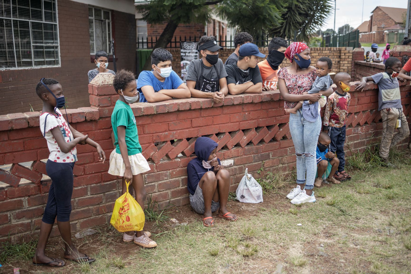 Crianças e adolescentes em fila para receber comida em Johannesburgo, África do Sul: pandemia aumento em 40% número de pessoas em insegurança alimentar aguda (Foto: Michele Spatari / AFP - 26/02/2021)