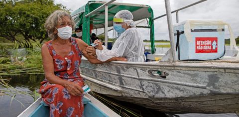 Olga D'arc Pimentel, de 72 anos, é vacinada por um profissional de saúde com uma dose da vacina Oxford-AstraZeneca na comunidade Nossa Senhora do Livramento às margens do Rio Negro perto de Manaus. Foto Michael Dantas/AFP
