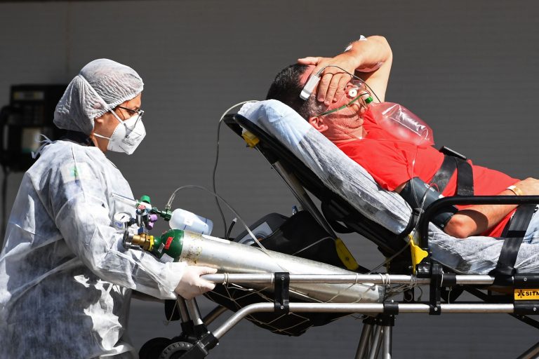 Paciente com covid-19 chega de ambulância a um hospital público em Brasília. Os últimos boletins indicam que quase todos os leitos de UTI da capital estão ocupados. Foto Evaristo Sá/AFP. Março/2021