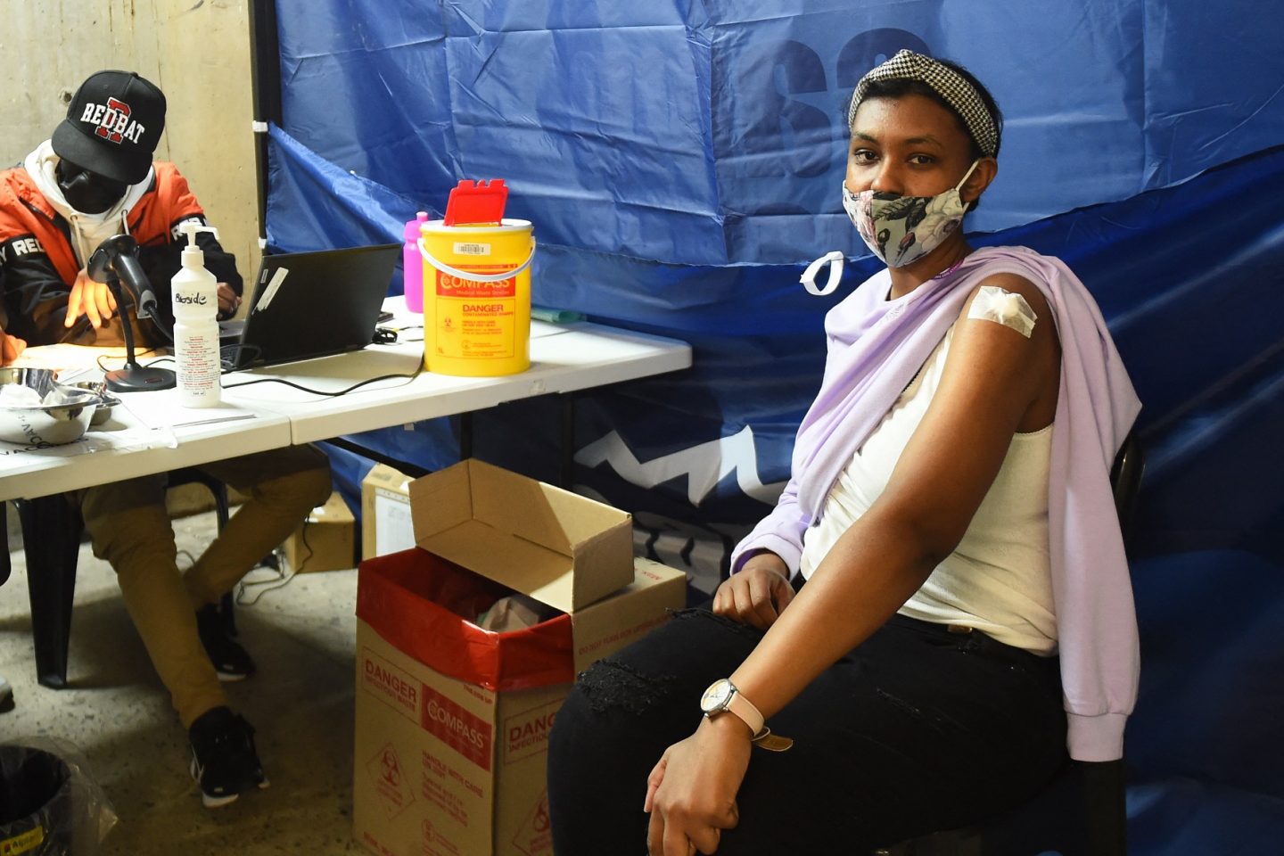 Jovem é atendida em posto de vacinação na Cidade do Cabo. Governo tem enfrentado dificuldades para convencer a população a se vacinar. Foto Xabiso Mkhabela/Anadoly Agency via AFP