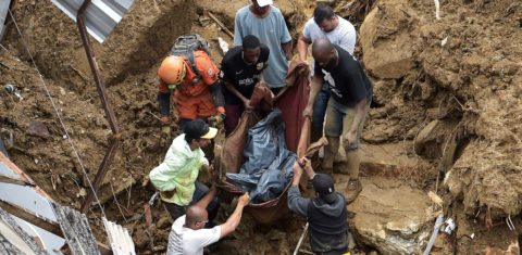 Voluntários retiram corpo de vítima do temporal em Petrópolis: número recorde de mortes marca maior catástrofe climática da Cidade Imperial (Foto: Carl de Souza / AFP)