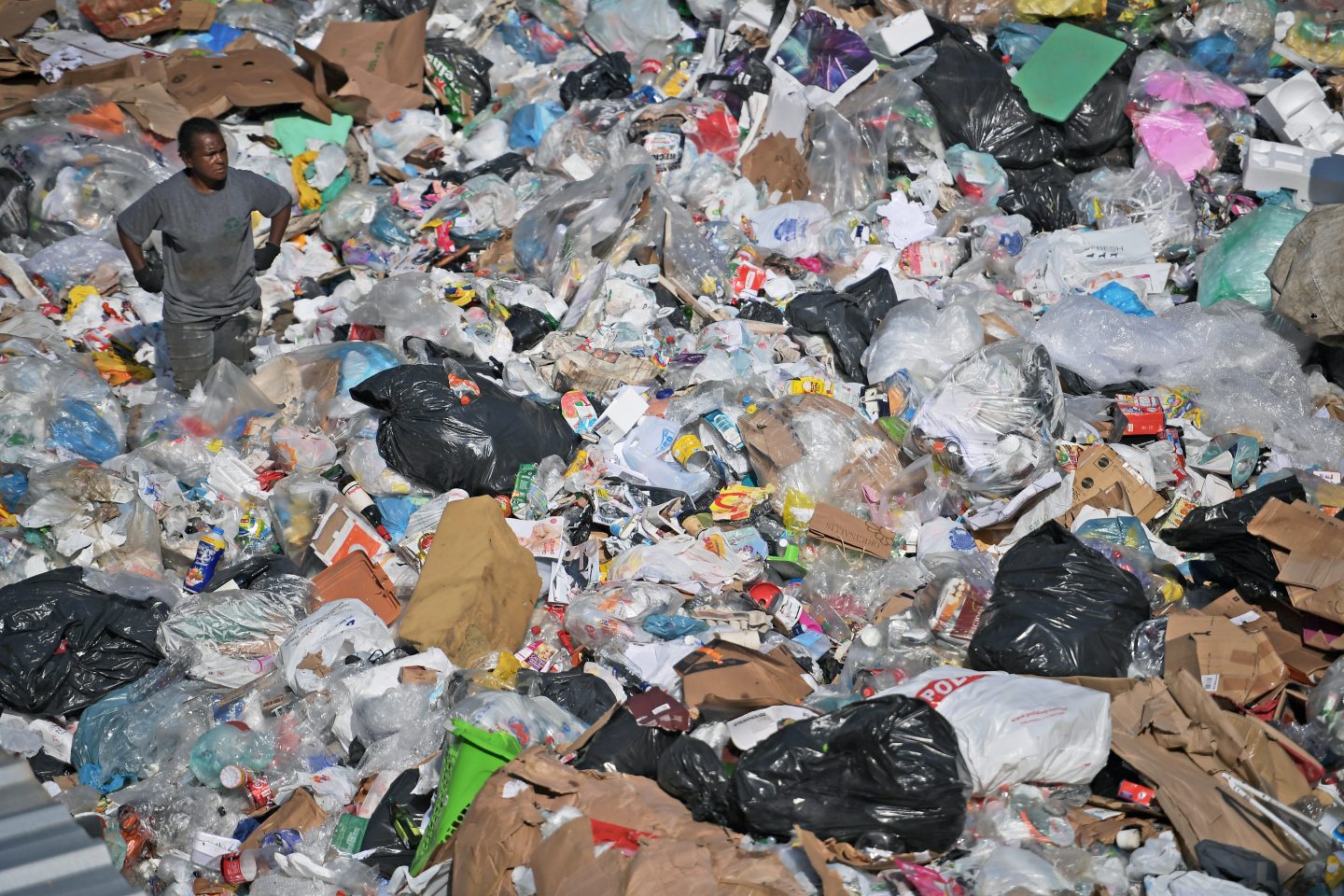 Trabalhador em meio ao lixo na CoopFuturo, uma cooperativa de reciclagem no Rio de Janeiro. O Brasil está entre os maiores recicladores de latinhas de alumínio do mundo. Foto Carl de Souza/AFP