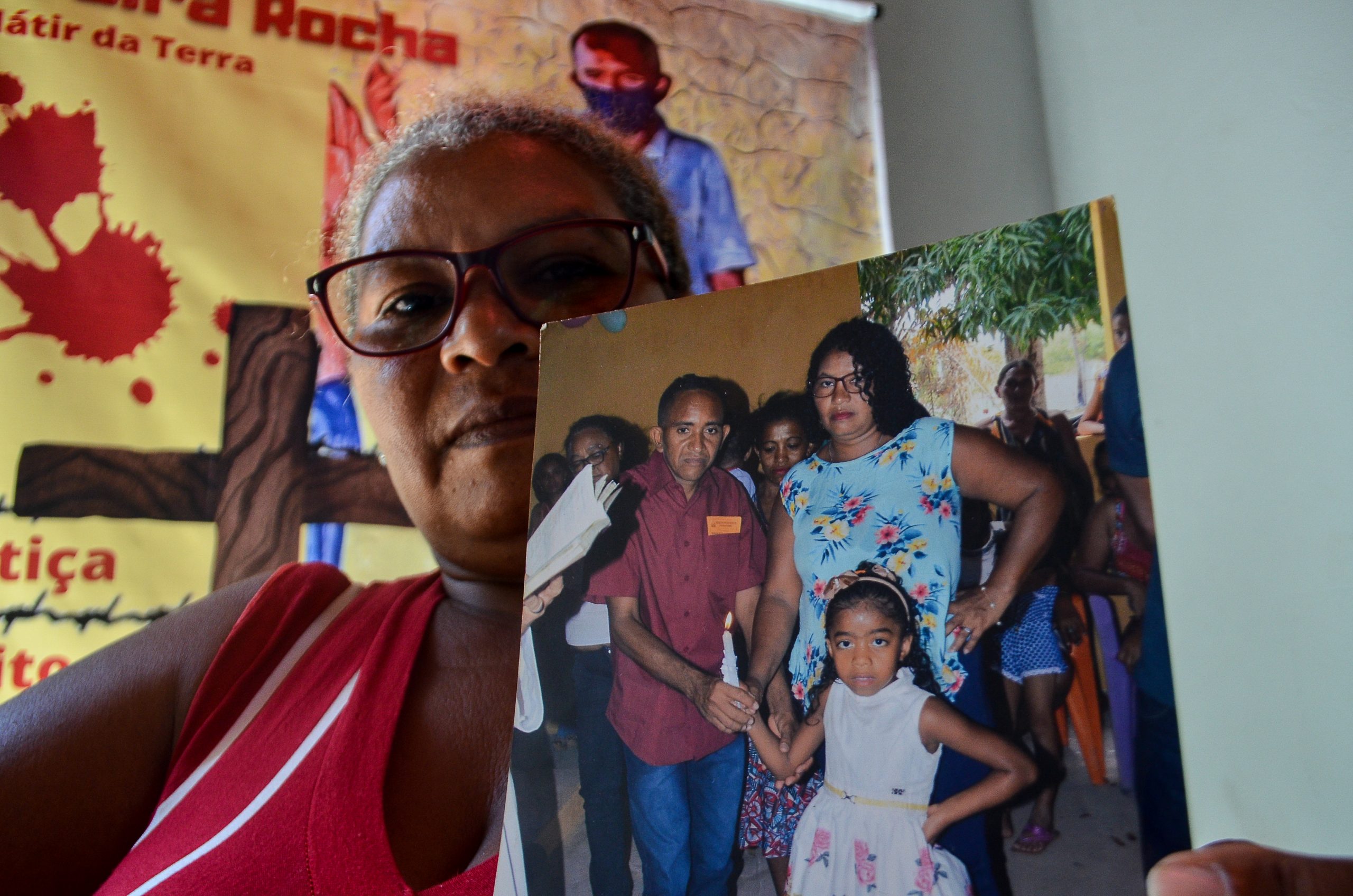 Dona Maria, viúva de Edvaldo, mostra foto do marido com a família: líder quilombola foi executado com oito tiros (Foto: João Paulo Guimarães)