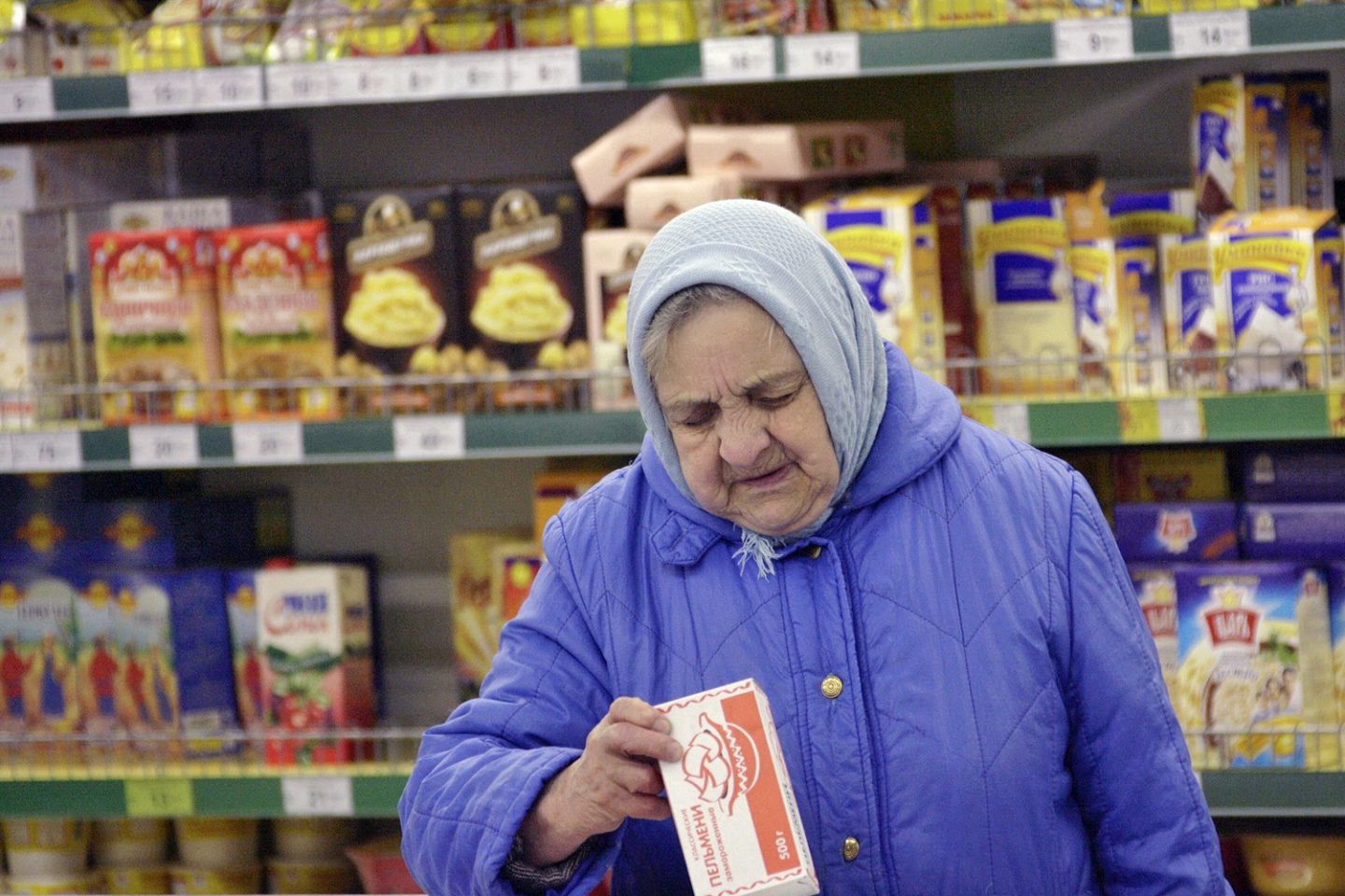 Disparada de preços dos alimentos bate recorde e atinge o mundo todo. Em um supermercado, em Moscou, mulher confere a etiqueta de um produto. Foto Krivobok Ruslan/Sputnik via AFP