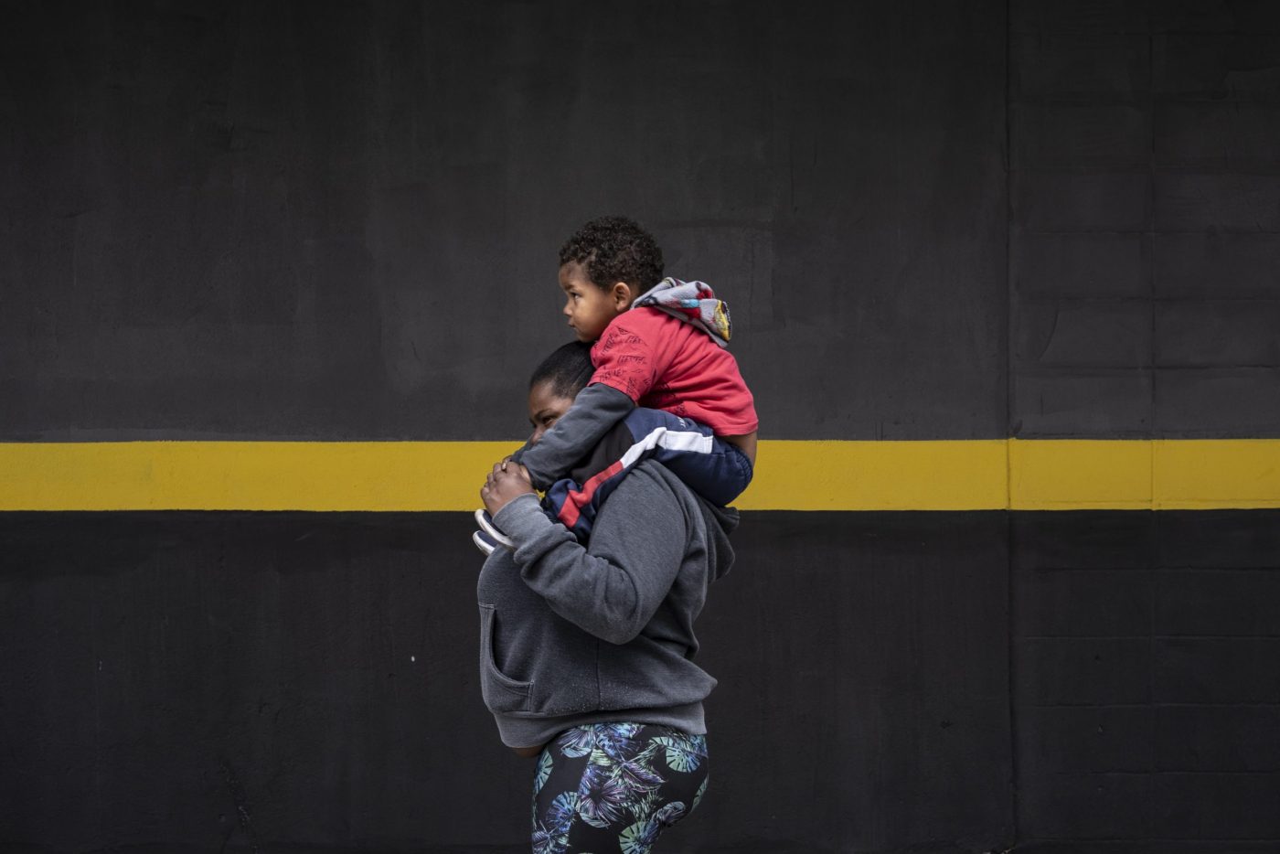 Mariana caminha com Kaleb até a estação de metrô onde ela trabalha vendendo doces, em São Paulo. Foto Dan Agostini/Diálogo Chino