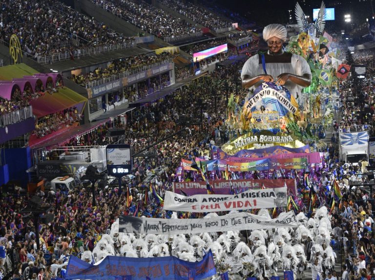 eija-Flor com suas faixas de protesto e a alegoria com a confecção de uma nova bandeira do Brasil: sucesso da escola mostra força de desfile politizado (Foto: Ismar Ingber / Riotur)