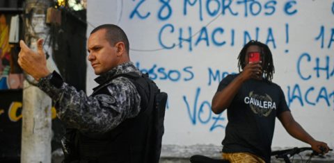 Morador filme a ação da polícia durante um protesto contra a ação policial na favela do Jacarezinho, no Rio. Foto André Borges/AFP