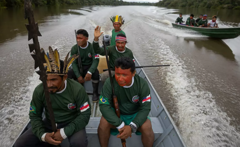 Cacique Mauro Kanamari, de cocar, (à esquerda) lidera grupo de Indígenas de Vigilância Territorial Kanamari durante monitoramento do Lago Caxias (Foto: Bruno Kelly/Amazônia Real)