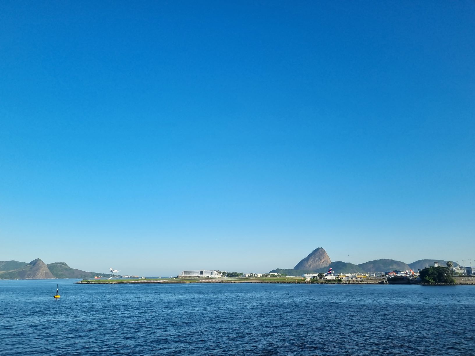 Da janela da barca, o Pão de Açúcar e as pista do Aeroporto Santos: águas calmas da Baía de Guanabara são convite à navegação desde que apenas os povos indígenas habitavam o Rio de Janeiro (Foto: Oscar Valporto)