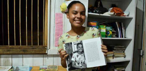 Emily Raiane, 17 anos, na Barca Literária, mostra o livro do qual participou como autora do posfácio. Foto João Paulo Guimarães