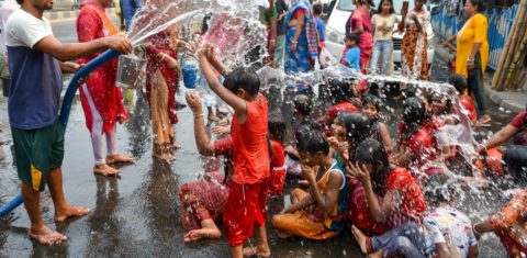 Crianças e adultos aproveitam água de carro-pipa para tomar banho e encher vasilhas em Kolkata, na Índia: onda de calor no abril mais quente da história na Ásia (Foto: Debarchan Chatterjee / NurPhoto / AFP - 15/04/2023)